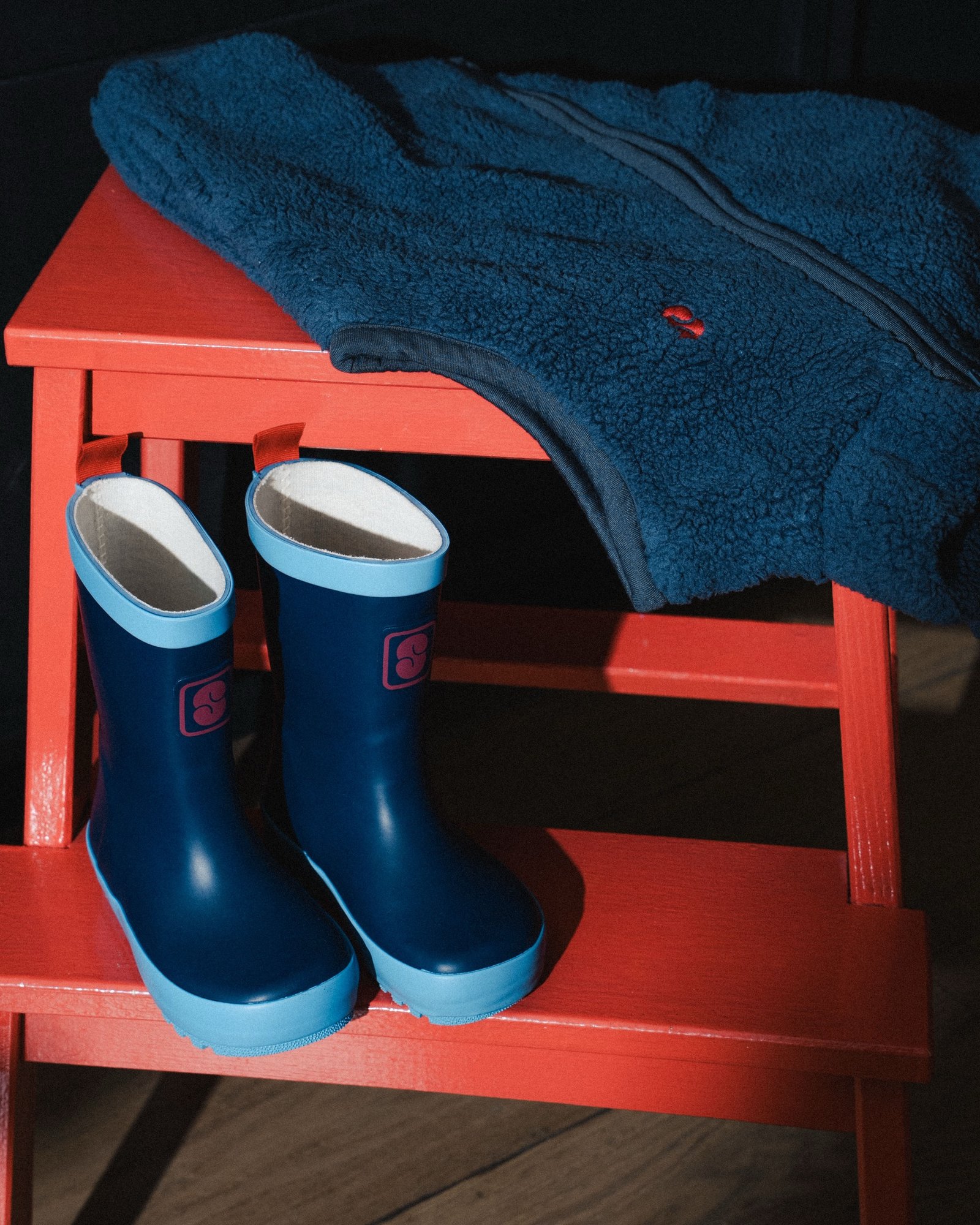 Smala — bottes de pluie posées sur un banc rouge